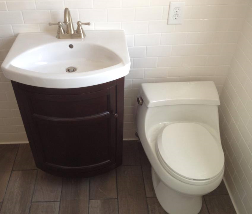 A newly installed white Toto comfort height toilet and simple but elegant vanity